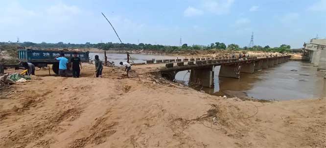 बाढ़ का पानी उतरने के बाद रेत माफिया सड़क पर बिखरी रेत की चोरी कर बेच रहे
